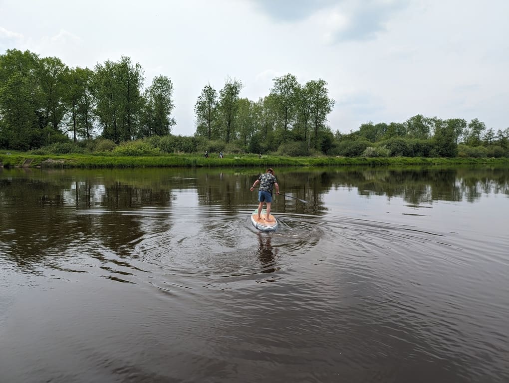 man testing the flex of a nixy newport g5 paddle board