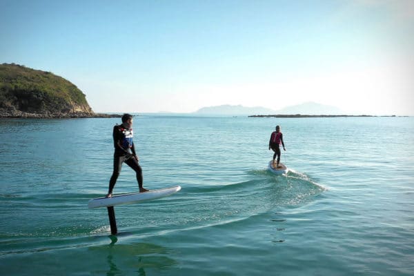 two people riding e foil boards