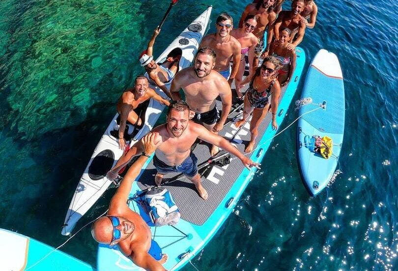 people on a giant paddle board