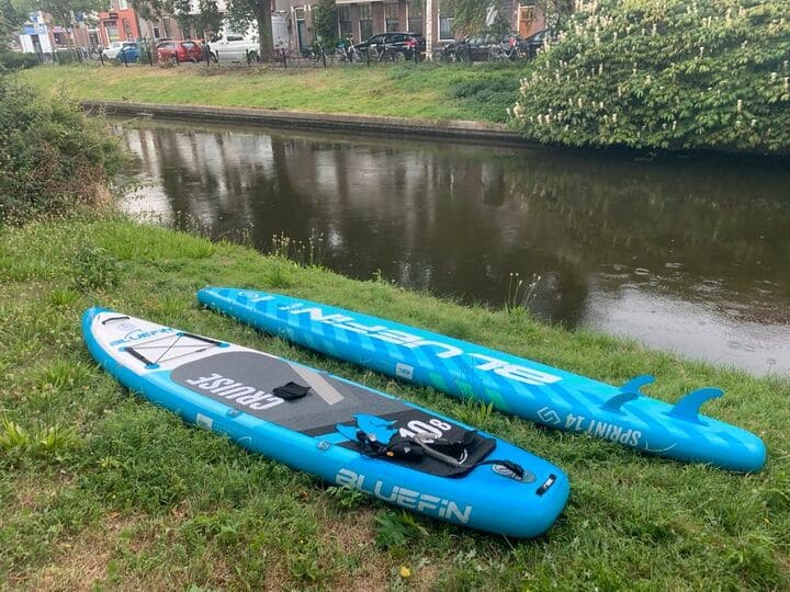 Bluefin paddle boards lying next to a river
